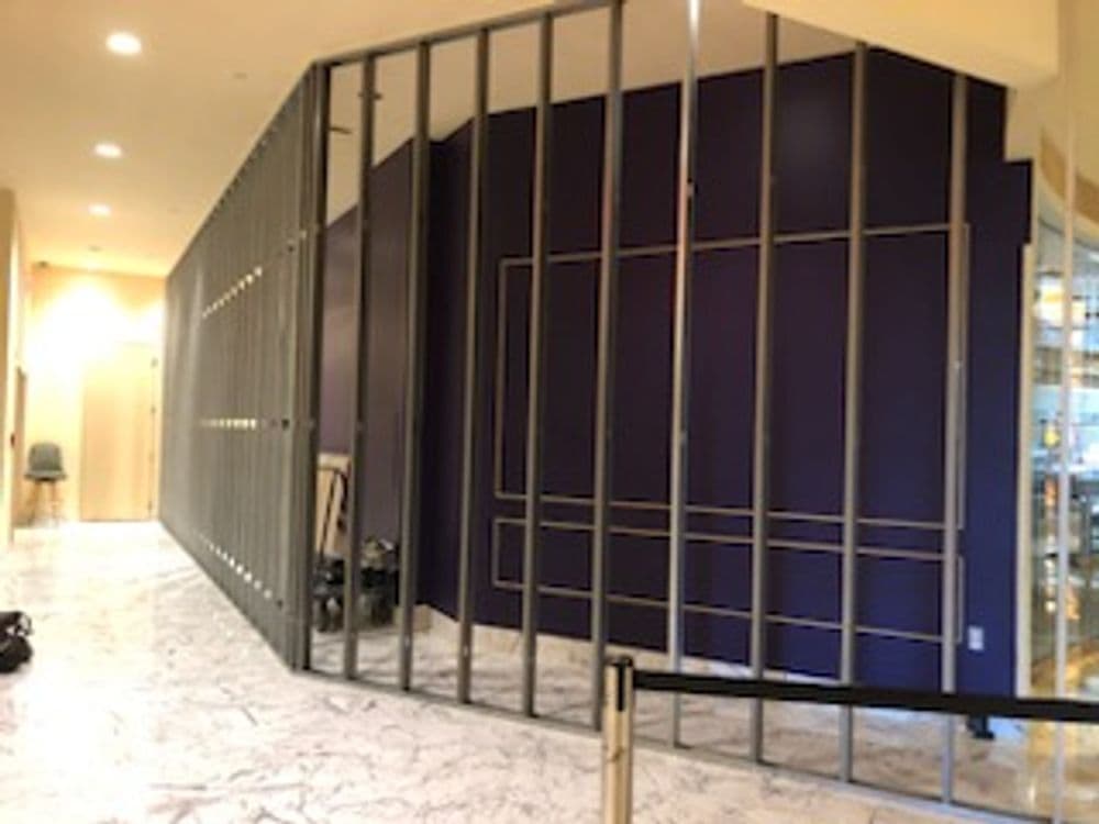 Interior construction with framed wall and dark purple accent, in a modern building lobby.