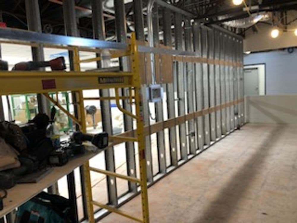 Construction site with metal framing and scaffolding, showcasing interior renovation progress.